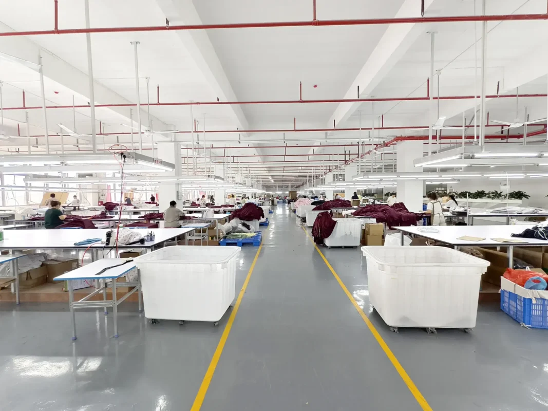 Garment inspection work area with clothing, worktables and production staff