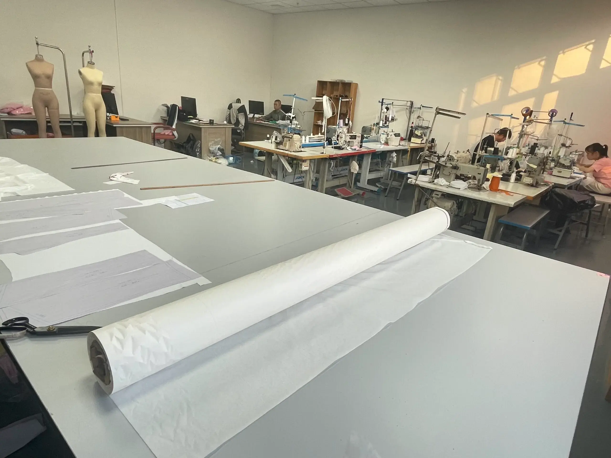 Garment sample room with pattern cutting table and sewing machines