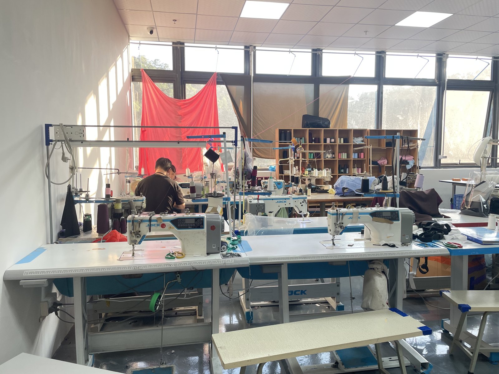 Worktables and sewing equipment in the sample development workroom.